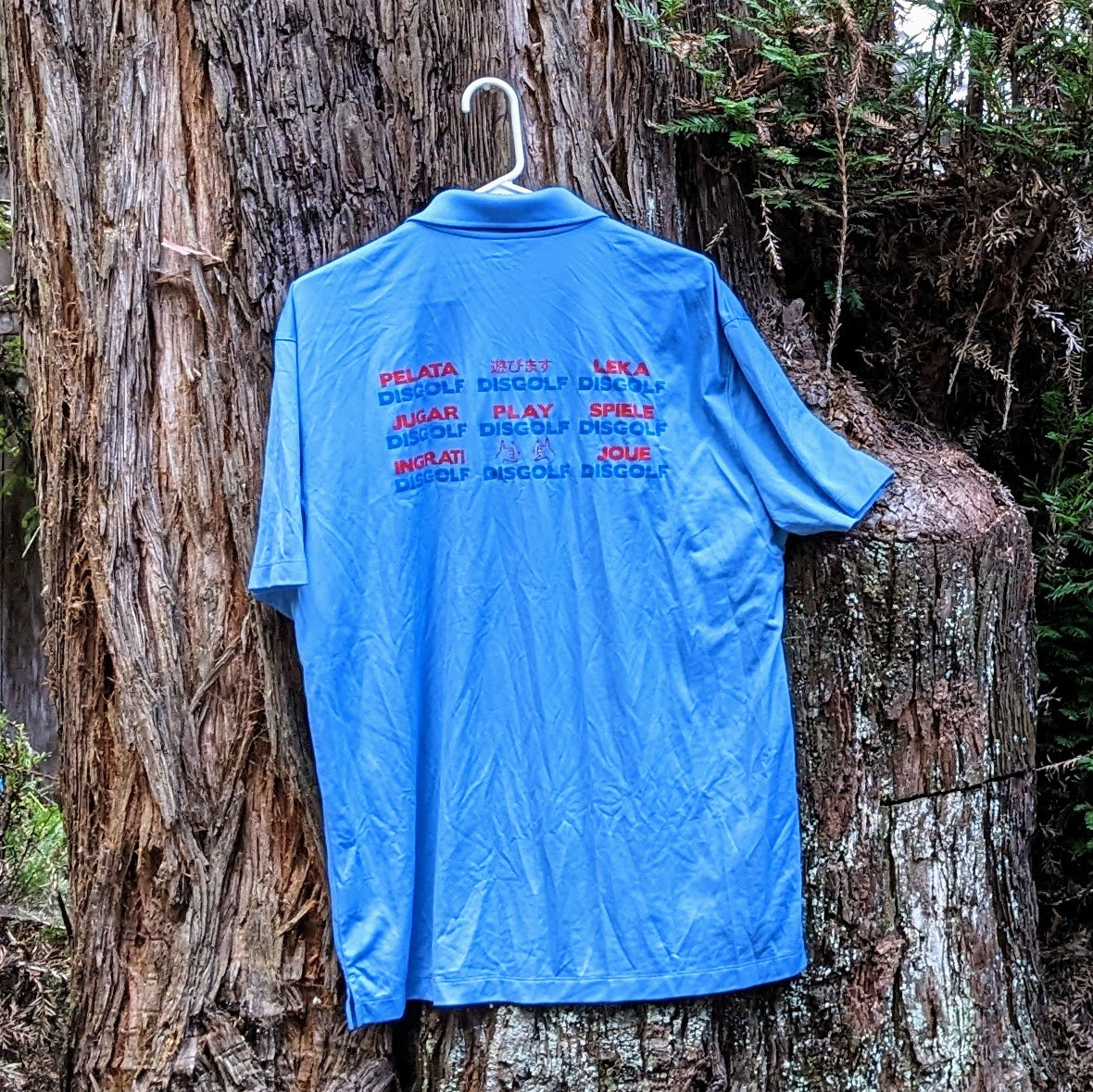 Clearance- Light blue performance polo with the Play DiscGolf logo front and Languages Grid version of logo on back, Size XL